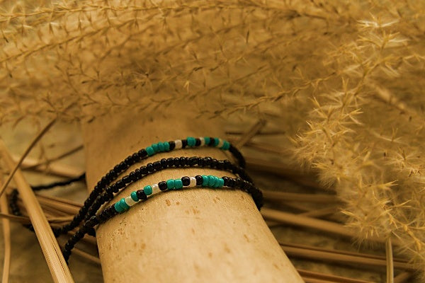 Handcrafted seed bead bracelet featuring the word 'faith' in Morse code with teal, white, and black beads.