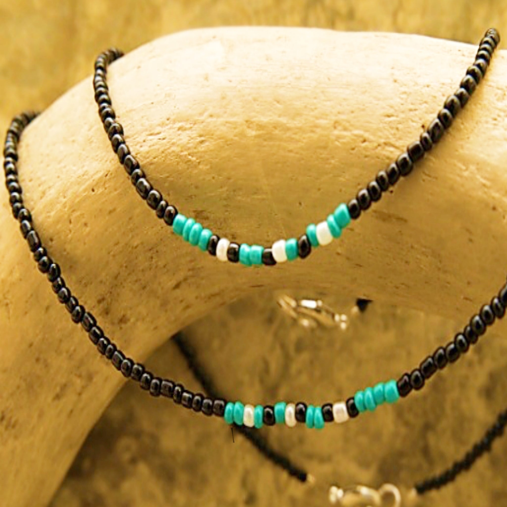 Handcrafted seed bead bracelet featuring the word 'faith' in Morse code with teal, white, and black beads.