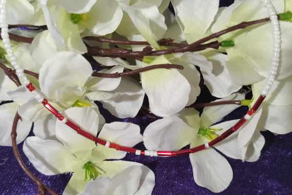 A handcrafted seed bead necklace featuring the phrase 'I Love You' in Morse Code, showcasing intricate beadwork and a delicate design.