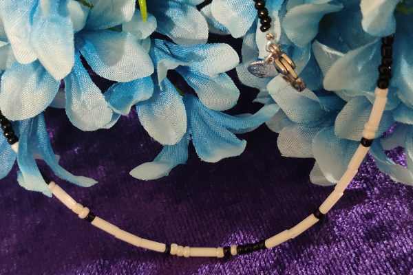 A handcrafted seed bead necklace featuring the phrase 'I Love You' in Morse Code, showcasing intricate beadwork and a delicate design.