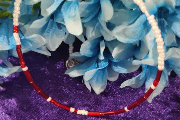 A handcrafted seed bead necklace featuring the phrase 'I Love You' in Morse Code, showcasing intricate beadwork and a delicate design.