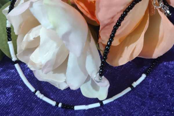 A handcrafted seed bead necklace featuring the phrase 'I Love You' in Morse Code, showcasing intricate beadwork and a delicate design.