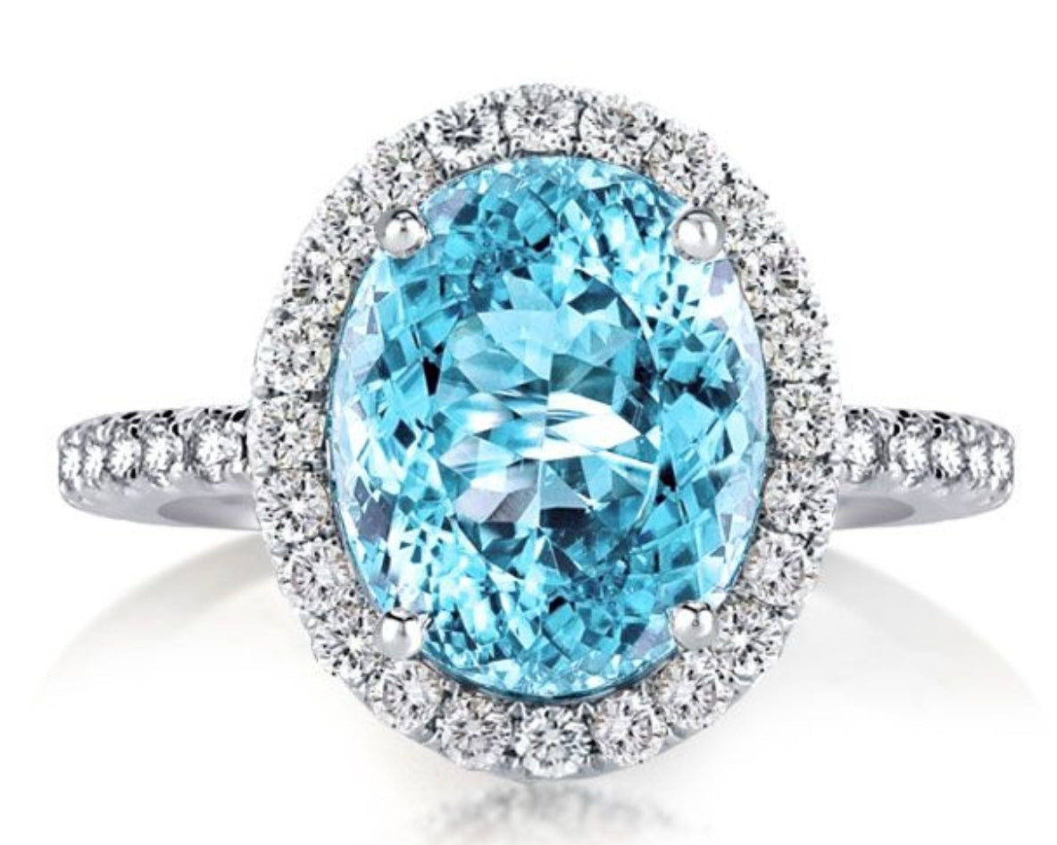 A beautiful aquamarine halo ring made of 925 sterling silver with white gold finish, featuring a central aquamarine stone surrounded by white sapphires.