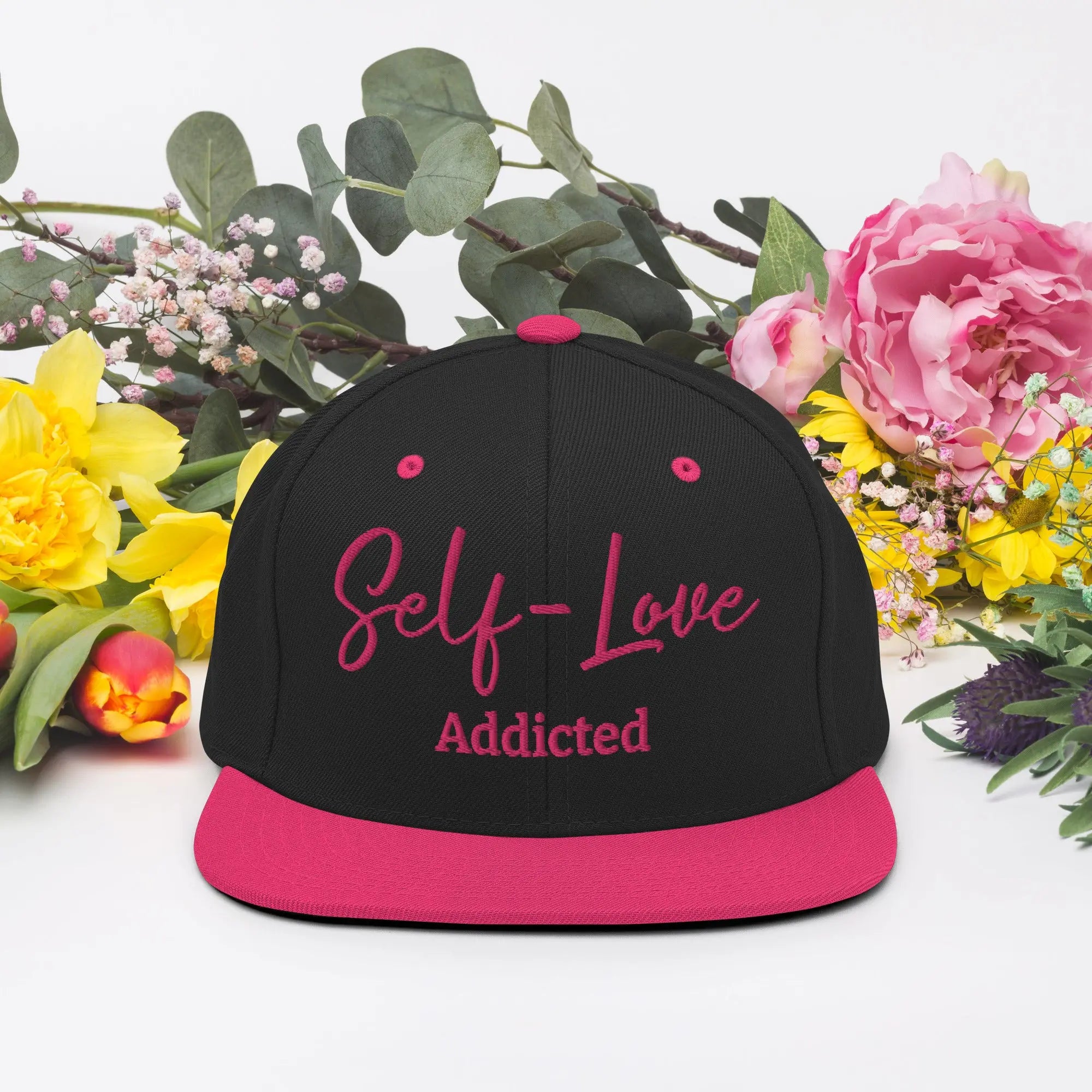 Self Love Addicted Snapback Hat with flat brim and embroidered details, showcasing a structured design and adjustable snap closure.
