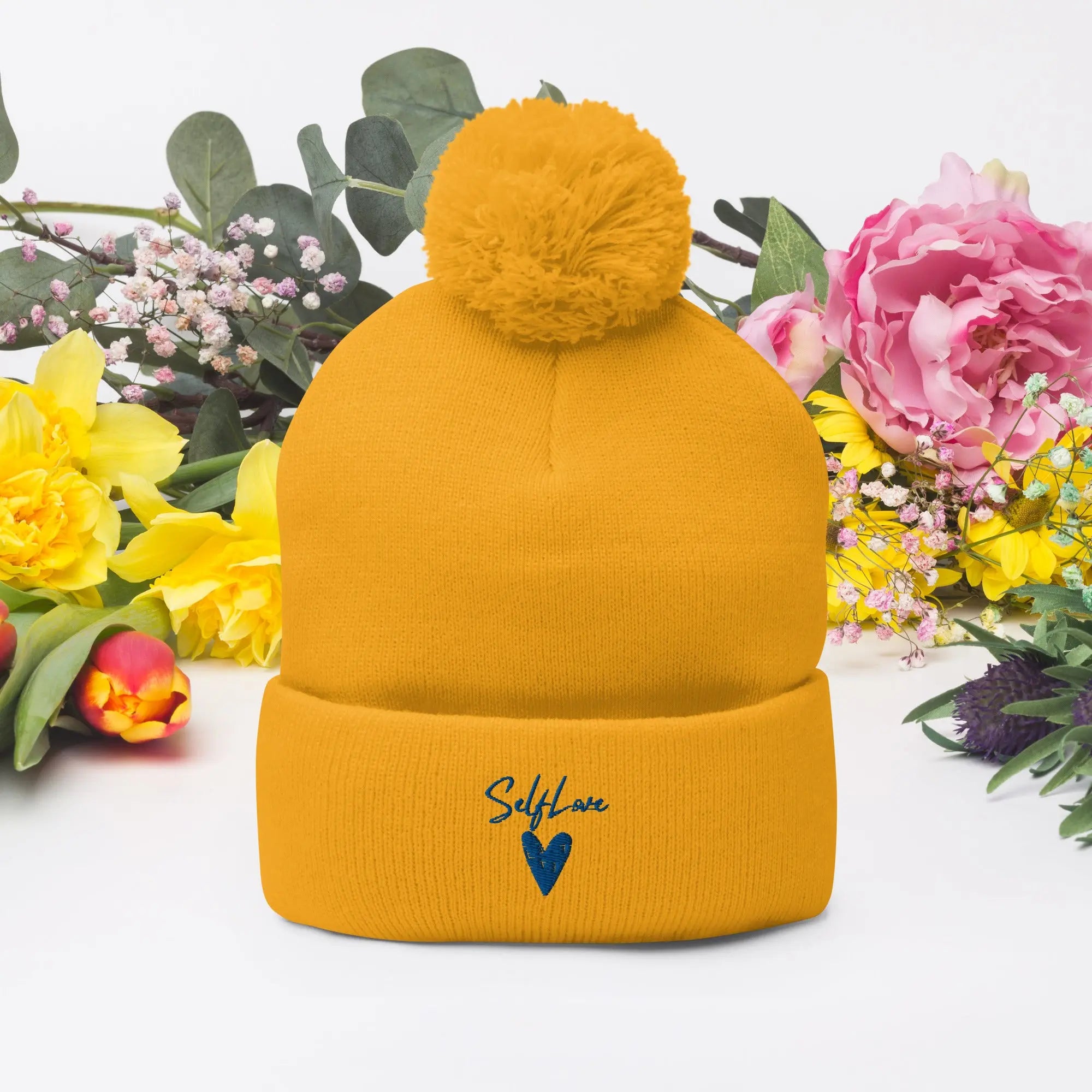 Self Love Pom-Pom Beanie featuring embroidered design and playful pom-pom, perfect for winter wear.
