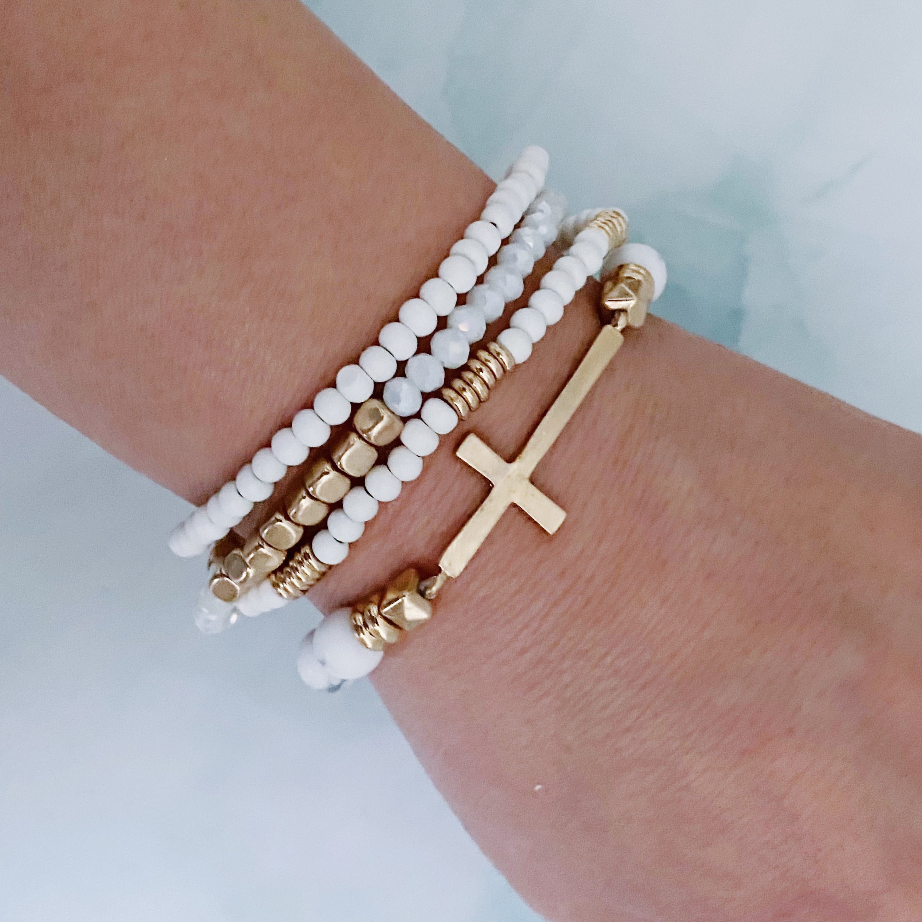 Set of 4 stylish bracelets featuring natural stone and wooden beads with a chic sided cross design.