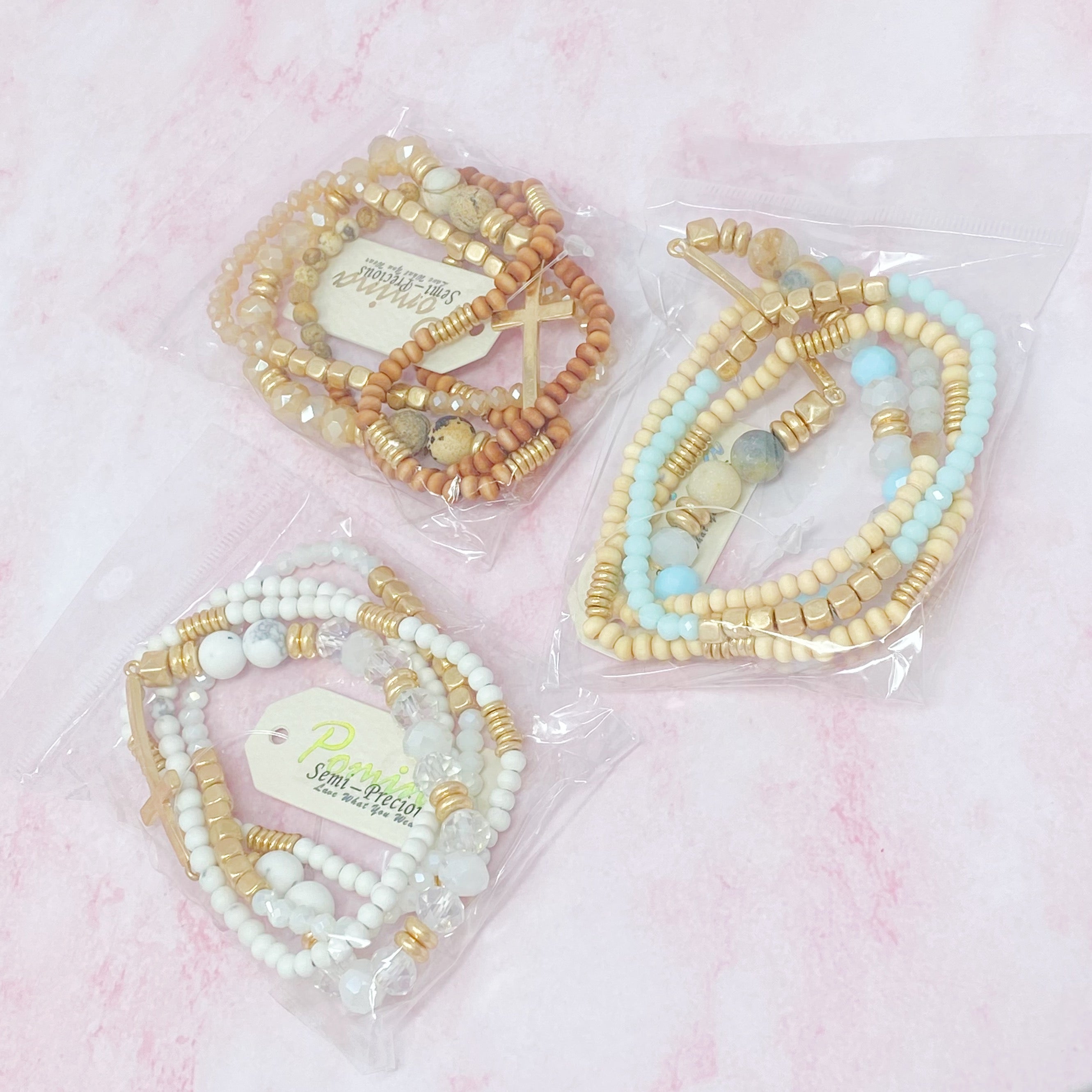 Set of 4 stylish bracelets featuring natural stone and wooden beads with a chic sided cross design.