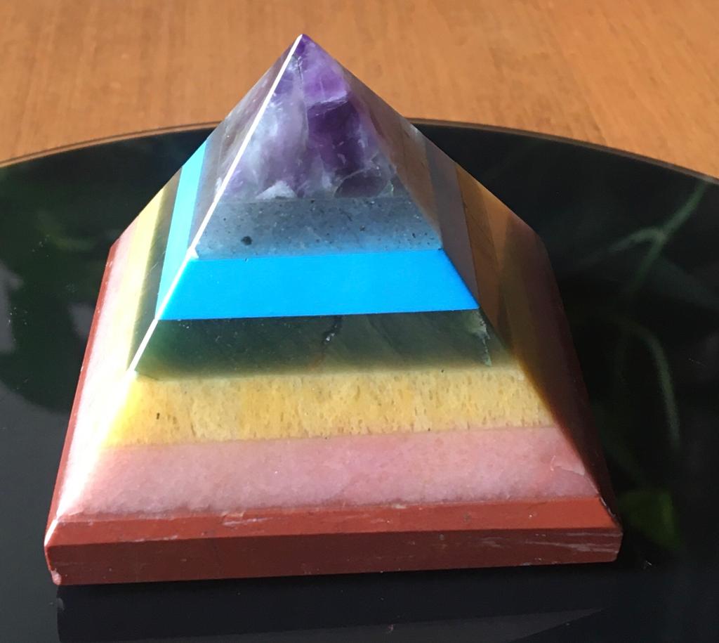 A colorful Seven Chakra Gemstone Pyramid made from natural gemstones, showcasing vibrant colors and intricate details.