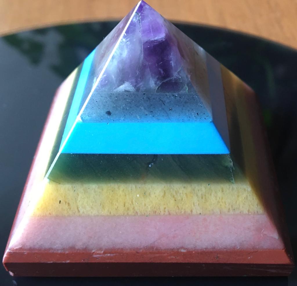 A colorful Seven Chakra Gemstone Pyramid made from natural gemstones, showcasing vibrant colors and intricate details.
