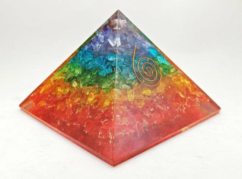 A beautifully crafted Seven Chakra Orgonite Pyramid featuring natural gemstones and copper, designed for energy healing and chakra balancing.