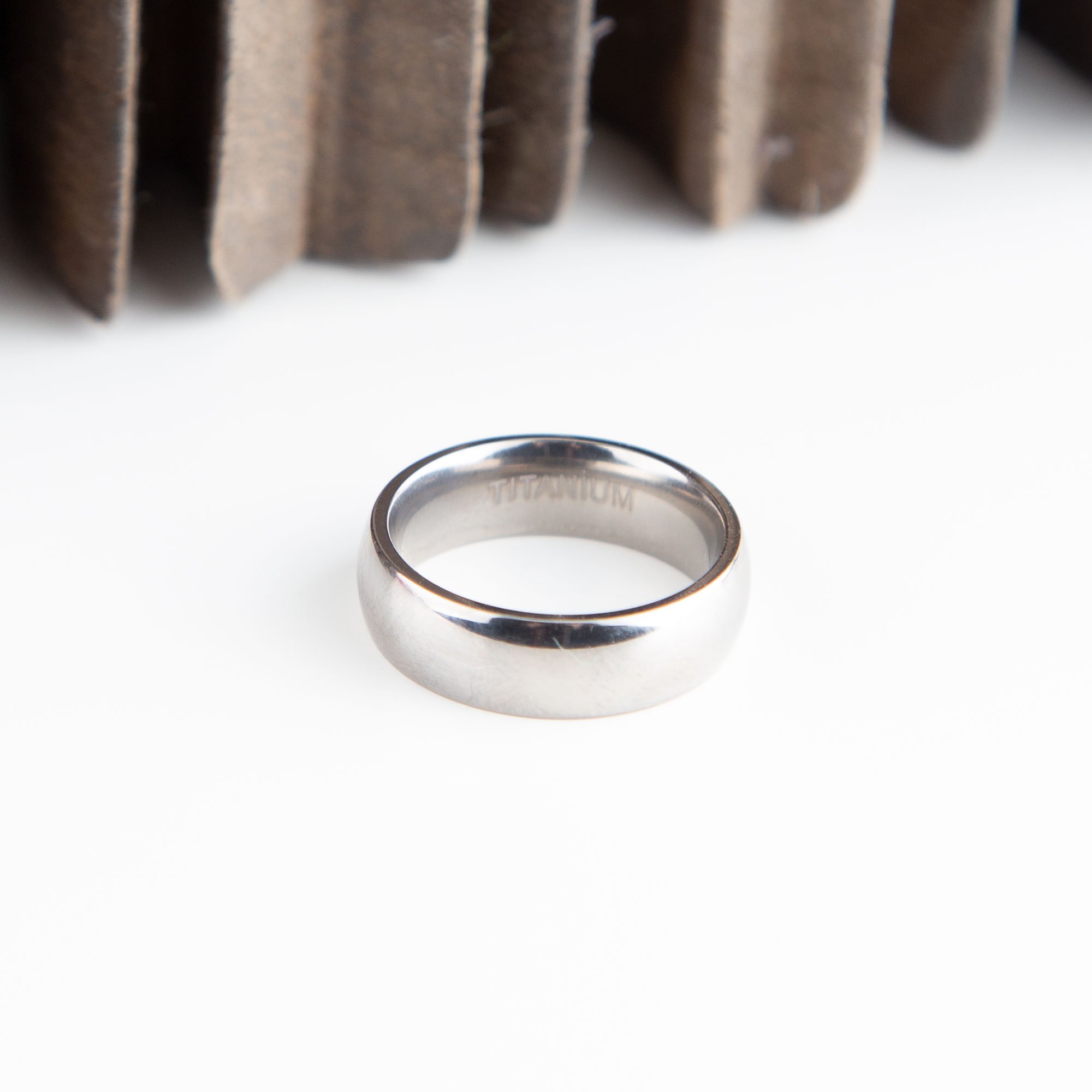 A shiny 6mm wide titanium ring with a polished finish, showcasing its lightweight and durable design, suitable for engraving.