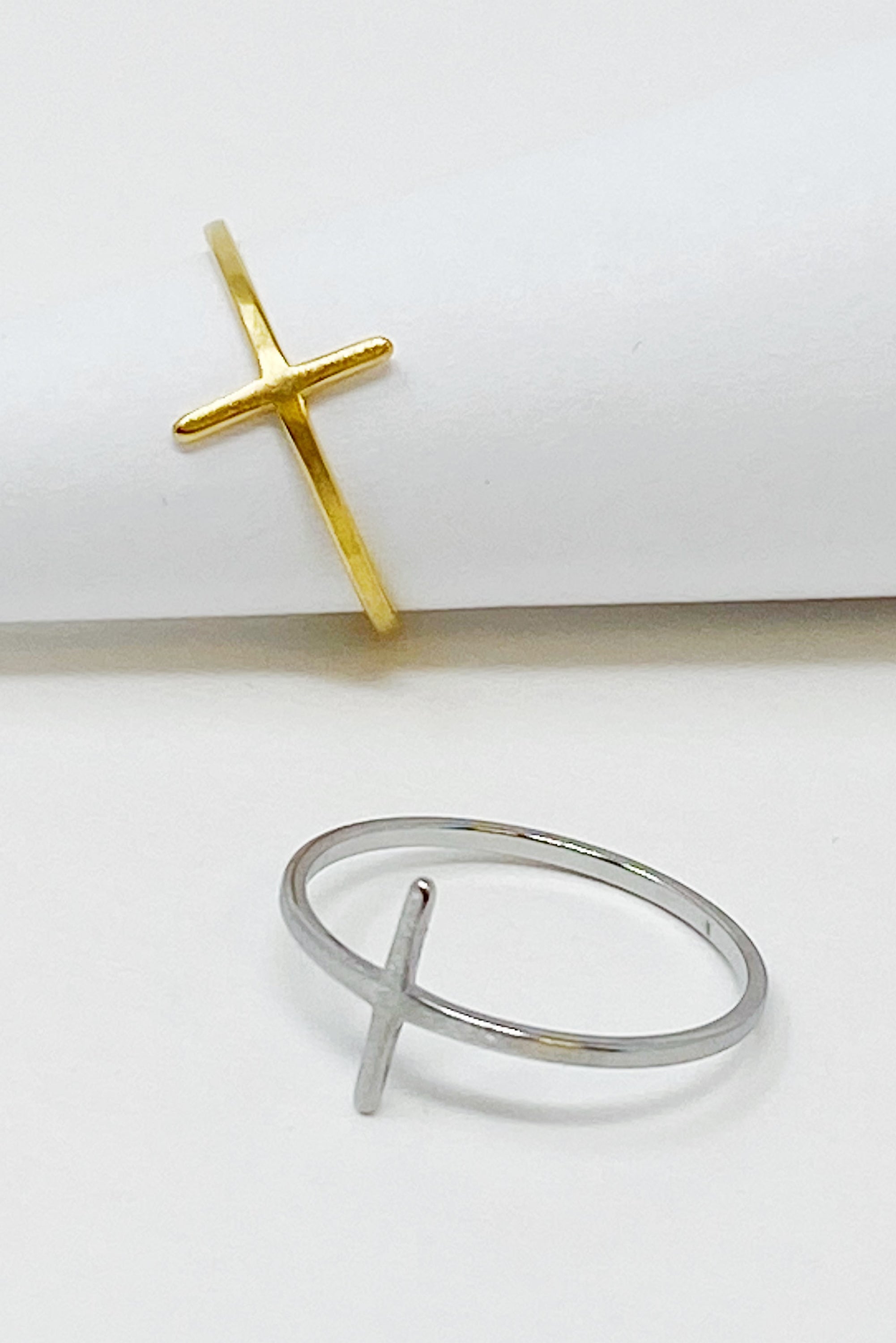 A slim dainty side cross ring made of stainless steel with 18K gold plating, showcasing its elegant design.