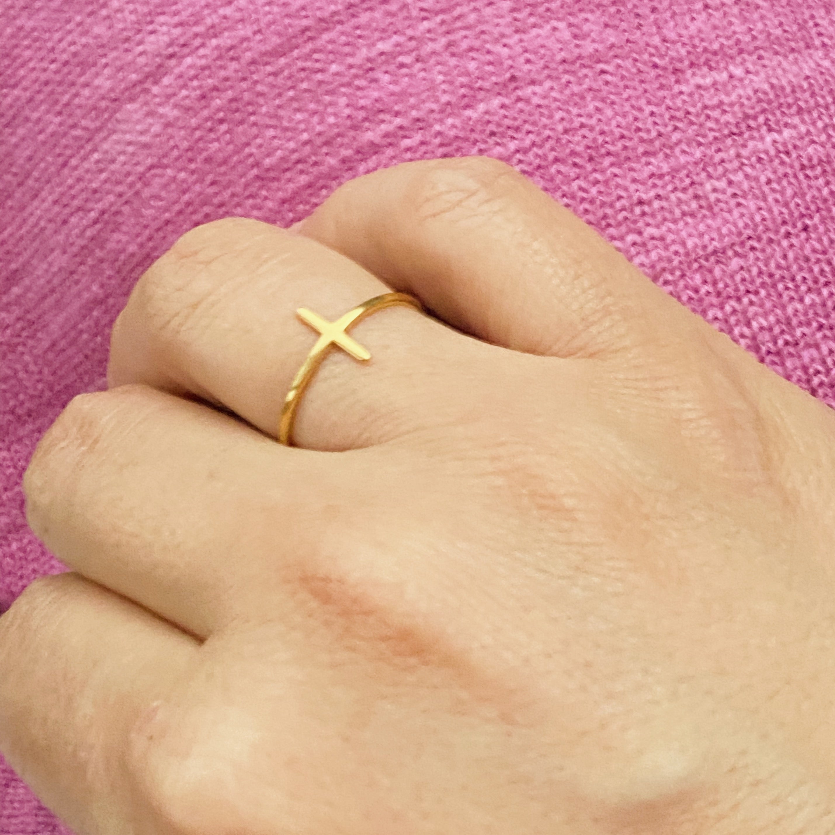 A slim dainty side cross ring made of stainless steel with 18K gold plating, showcasing its elegant design.