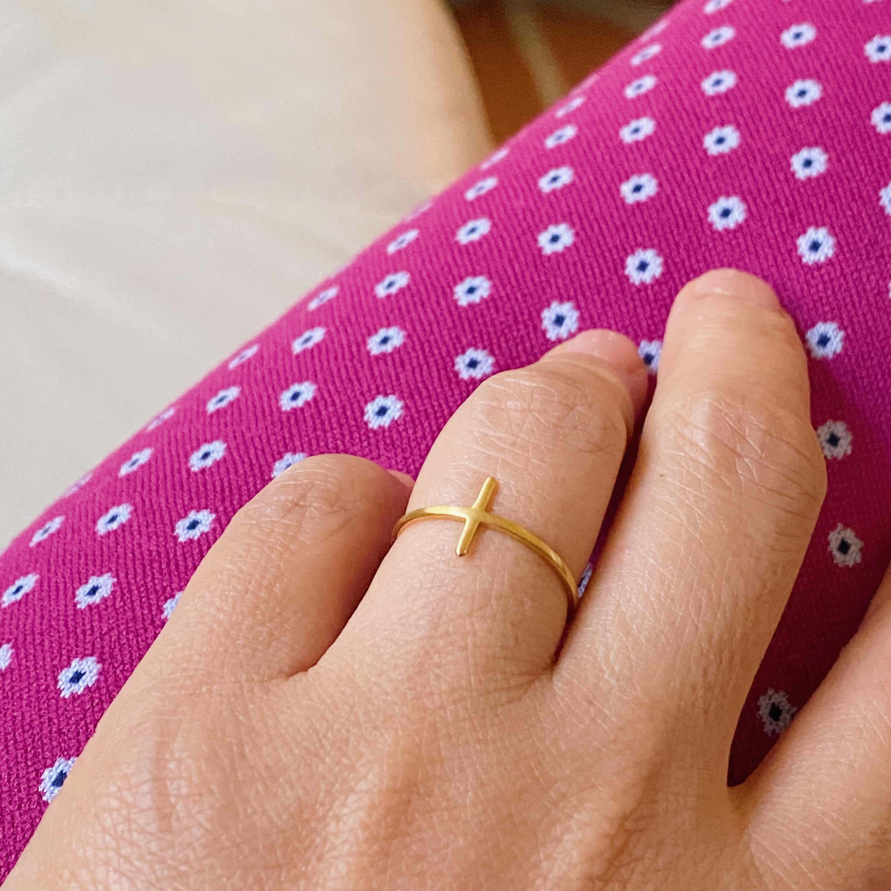 A slim dainty side cross ring made of stainless steel with 18K gold plating, showcasing its elegant design.