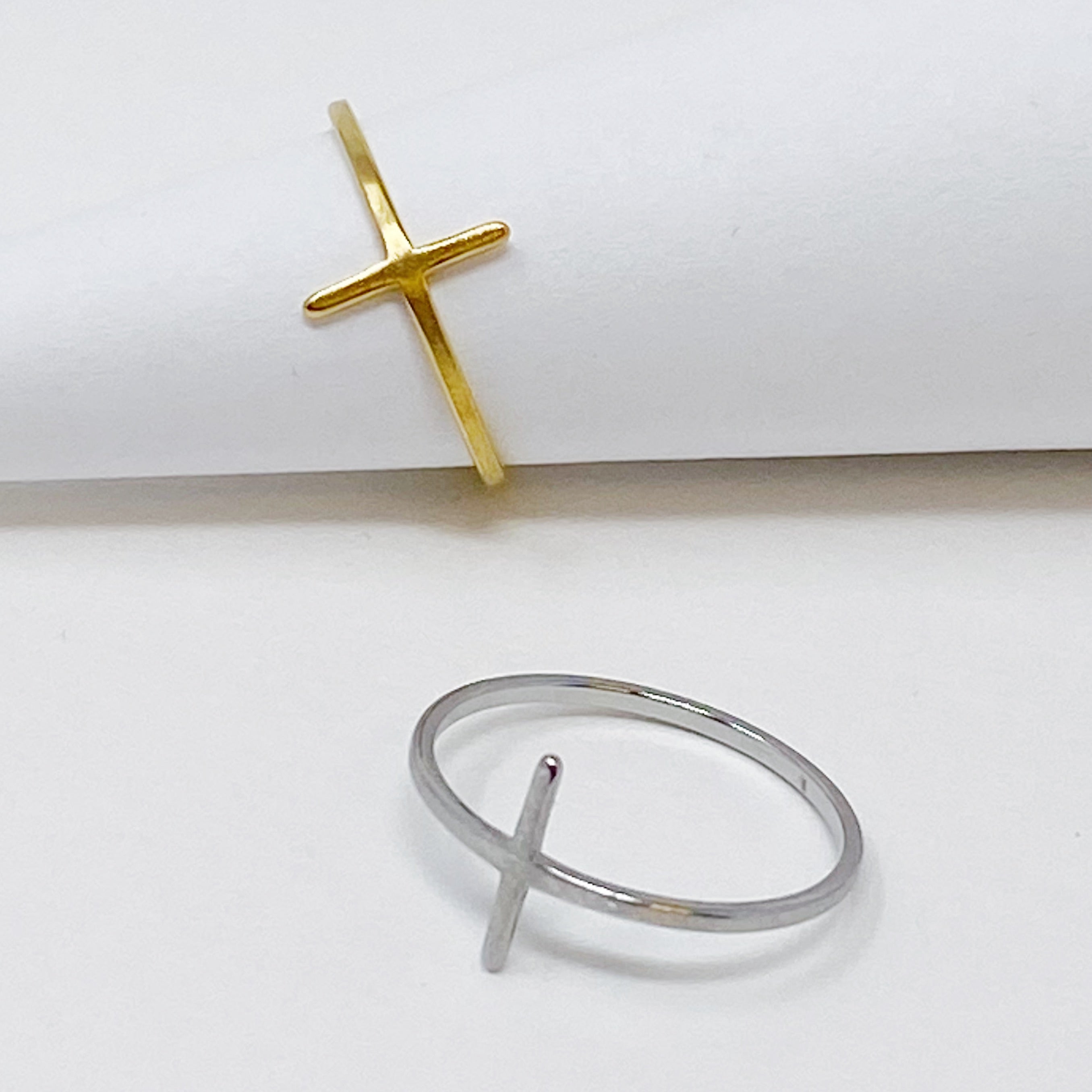 A slim dainty side cross ring made of stainless steel with 18K gold plating, showcasing its elegant design.