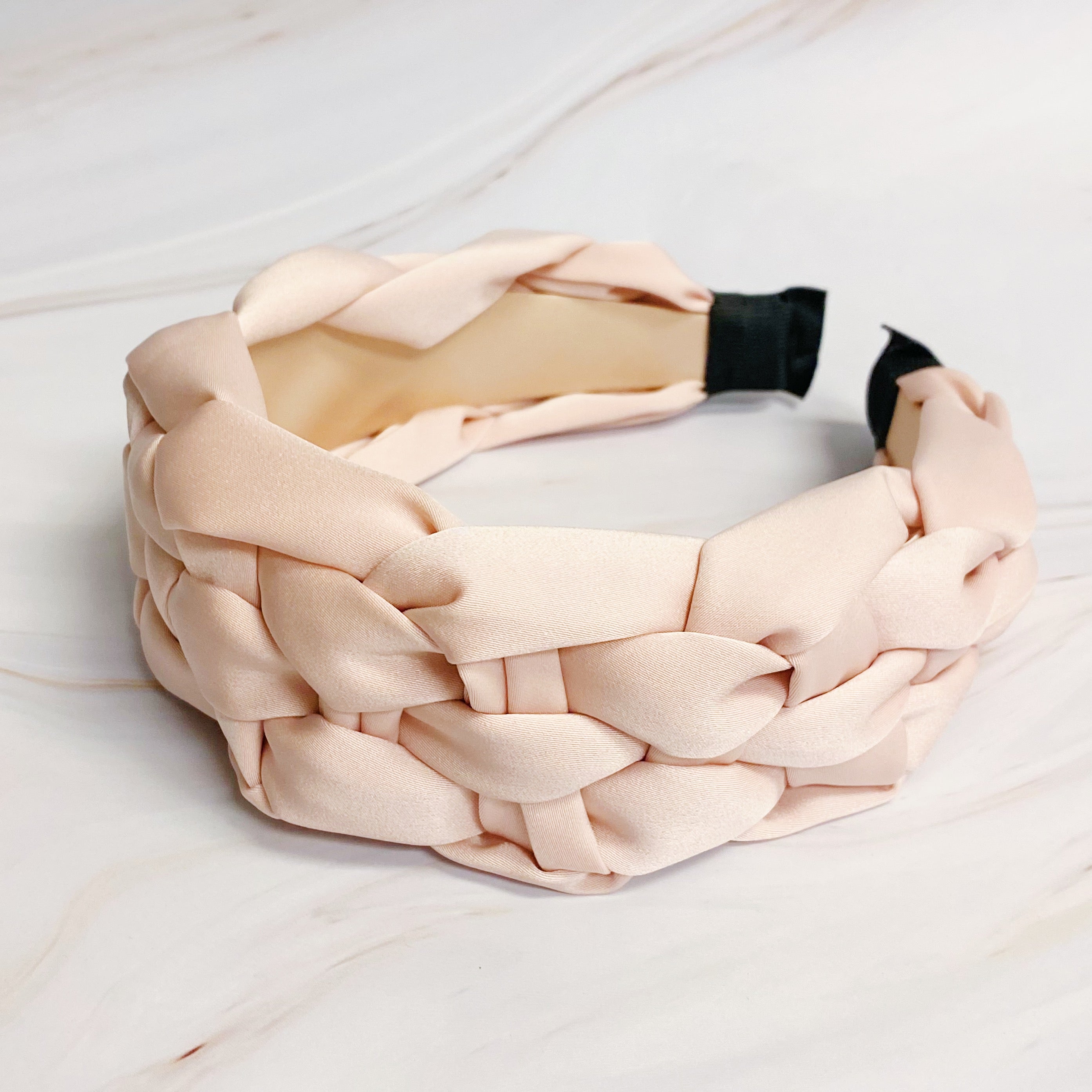 A luxurious silky woven headband featuring a hand-woven design, perfect for stylish comfort.