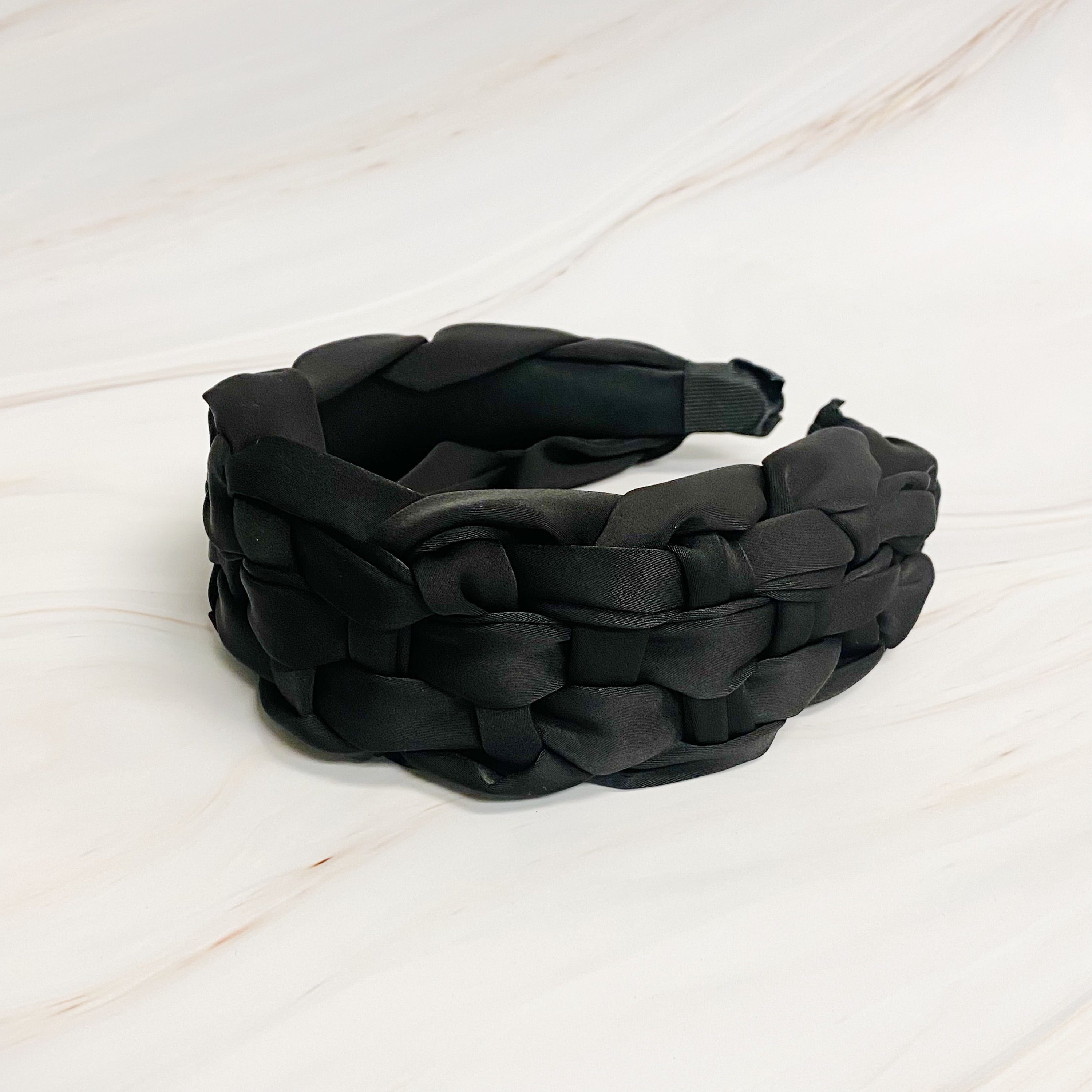 A luxurious silky woven headband featuring a hand-woven design, perfect for stylish comfort.