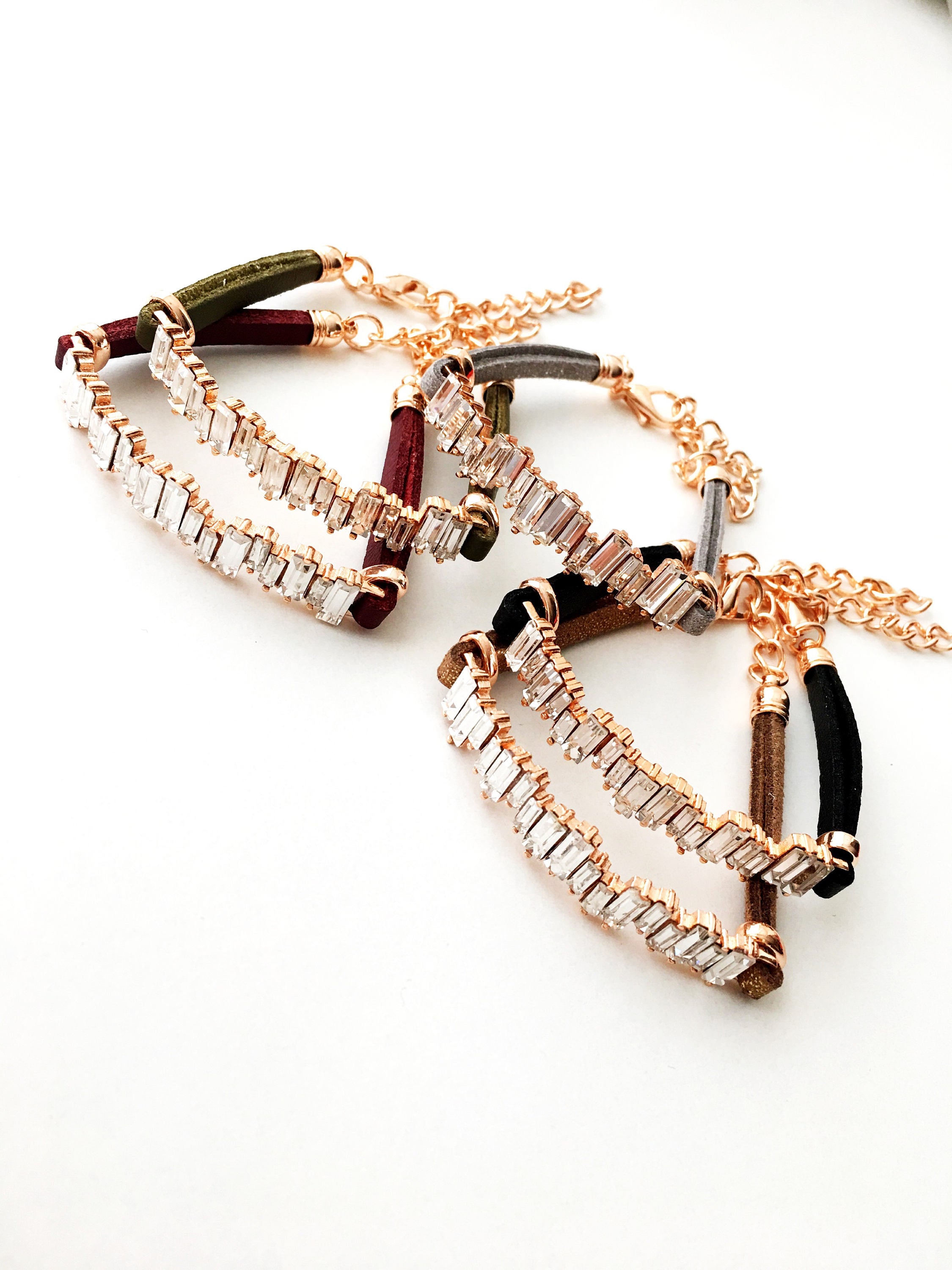 A beautiful set of handmade silver evil eye bracelets, featuring various designs including safety pin, baguette, and zirconia styles, all adjustable for comfort.