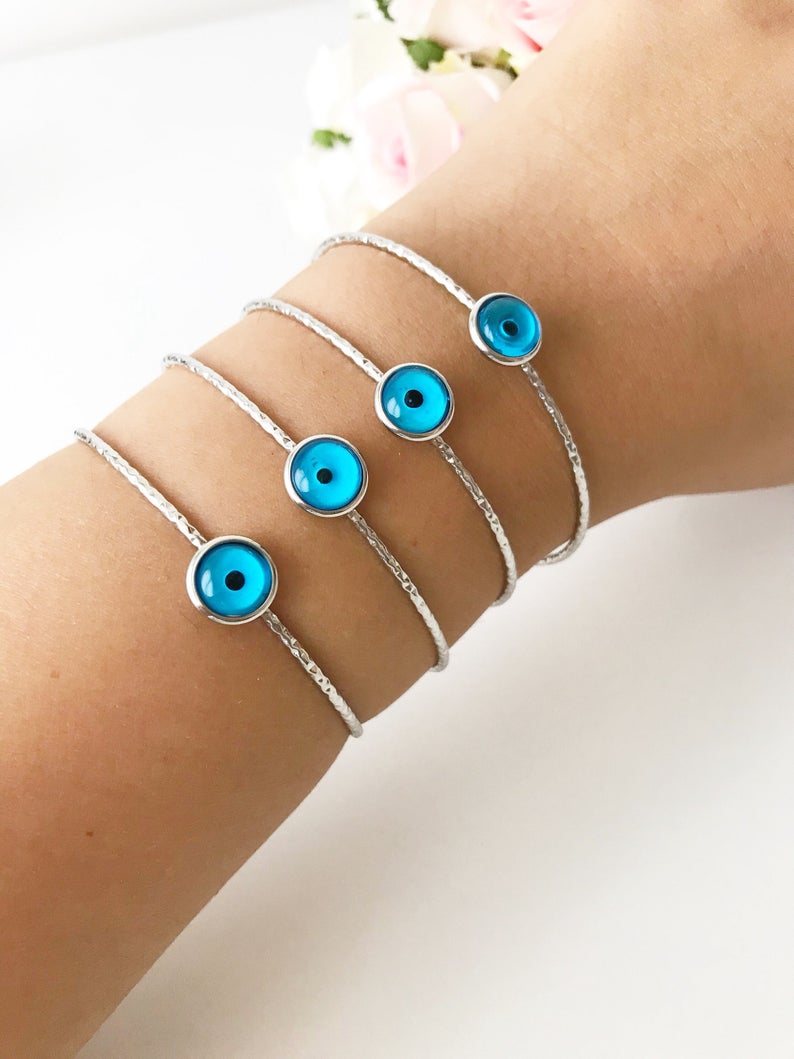 A delicate silver evil eye bracelet featuring a movable oval charm, crafted from tarnish-resistant stainless steel.