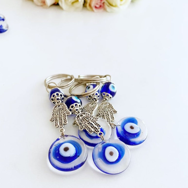 Silver Hamsa Evil Eye Keychain featuring a blue glass bead, elegantly designed with a hamsa hand charm.