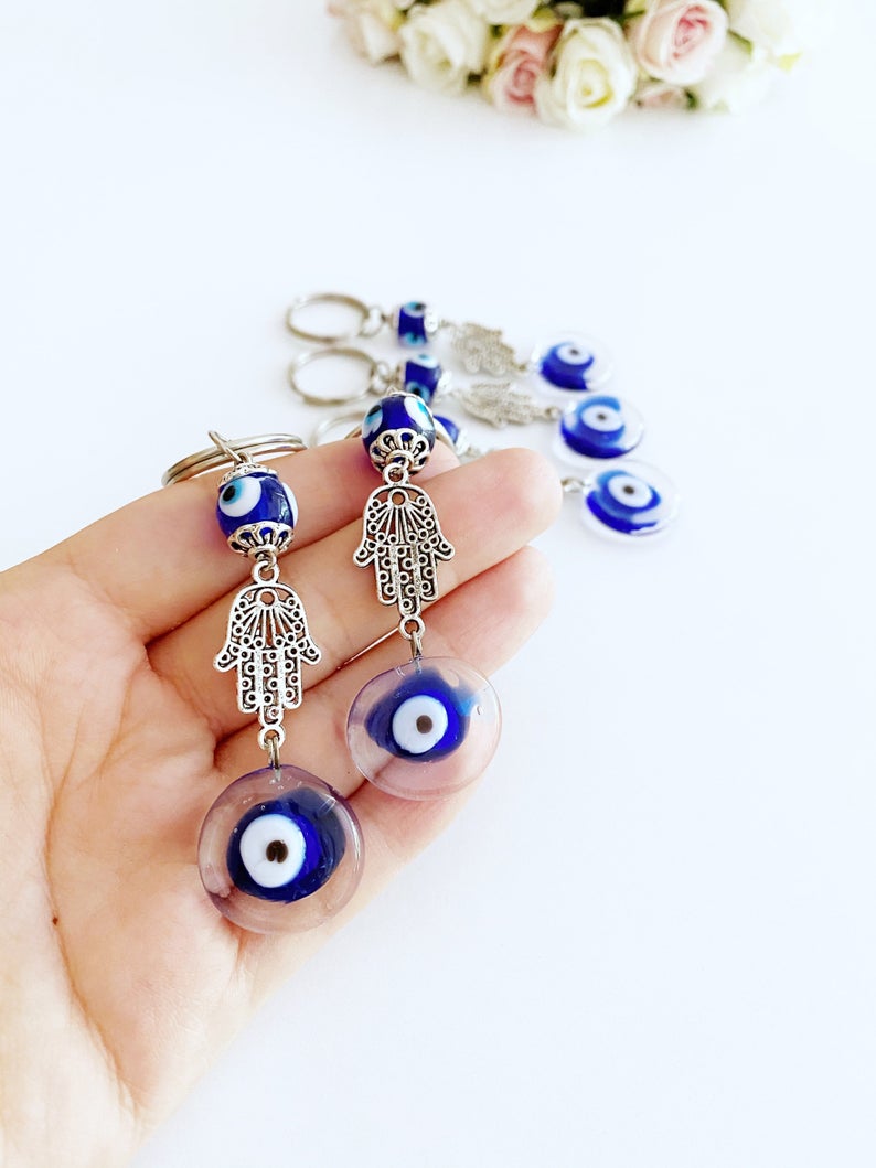 Silver Hamsa Evil Eye Keychain featuring a blue glass bead, elegantly designed with a hamsa hand charm.