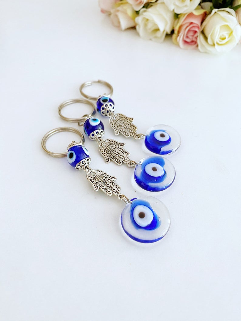 Silver Hamsa Evil Eye Keychain featuring a blue glass bead, elegantly designed with a hamsa hand charm.