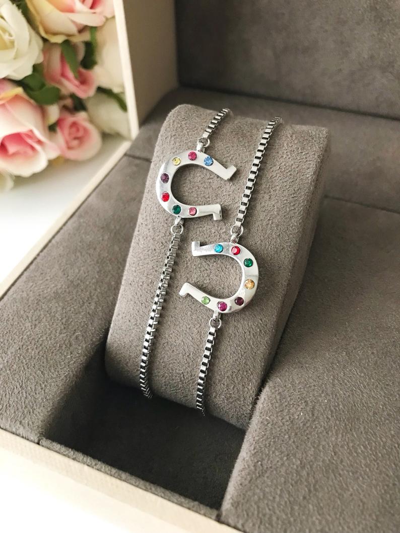 A beautiful silver horseshoe bracelet featuring a zirconia charm, adjustable design, and tarnish-resistant stainless steel material.