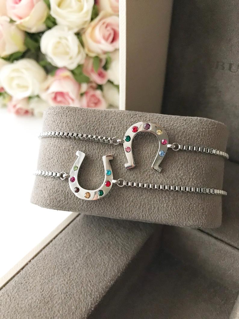 A beautiful silver horseshoe bracelet featuring a zirconia charm, adjustable design, and tarnish-resistant stainless steel material.