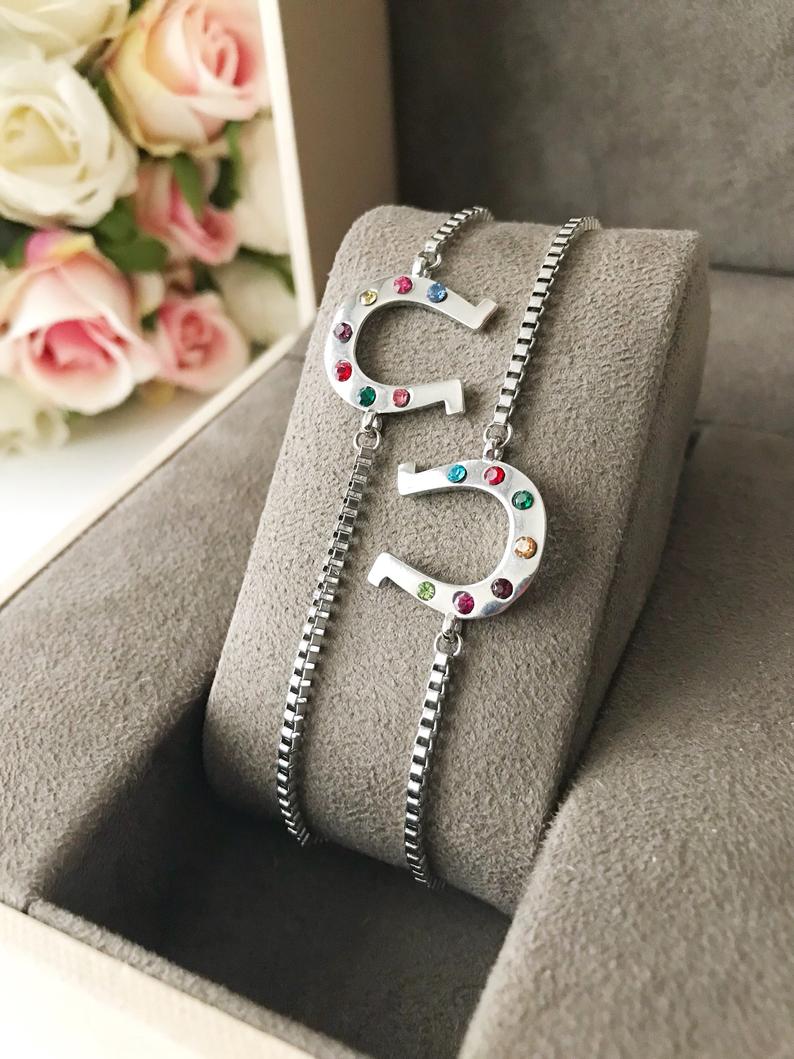 A beautiful silver horseshoe bracelet featuring a zirconia charm, adjustable design, and tarnish-resistant stainless steel material.