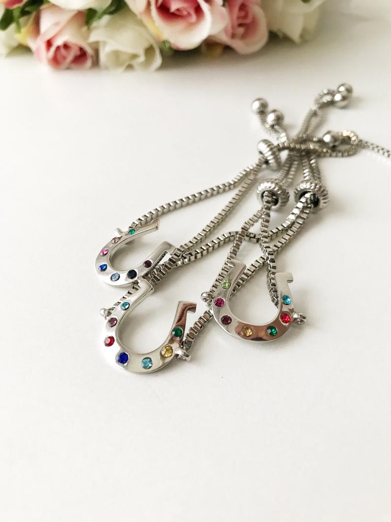 A beautiful silver horseshoe bracelet featuring a zirconia charm, adjustable design, and tarnish-resistant stainless steel material.