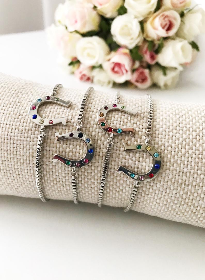 A beautiful silver horseshoe bracelet featuring a zirconia charm, adjustable design, and tarnish-resistant stainless steel material.