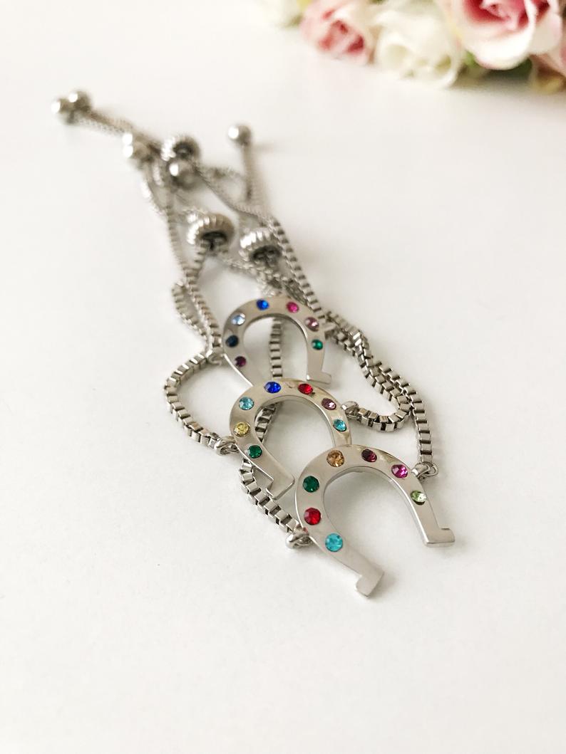 A beautiful silver horseshoe bracelet featuring a zirconia charm, adjustable design, and tarnish-resistant stainless steel material.