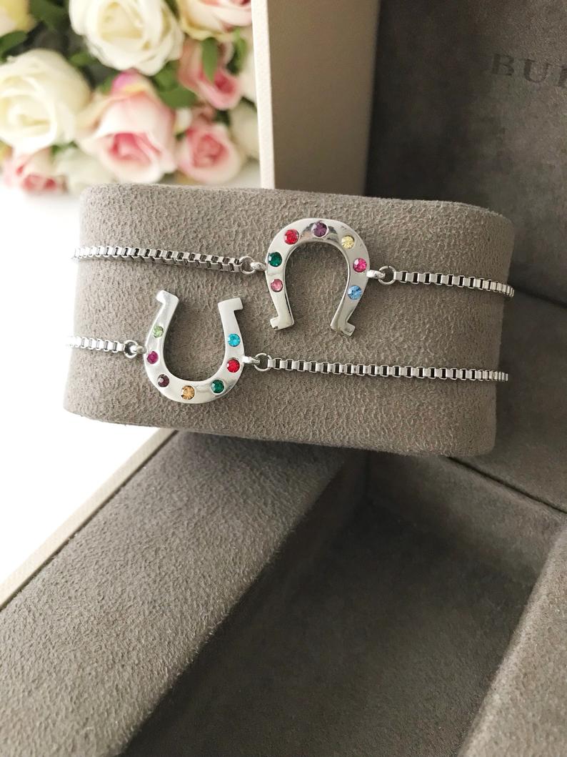A beautiful silver horseshoe bracelet featuring a zirconia charm, adjustable design, and tarnish-resistant stainless steel material.