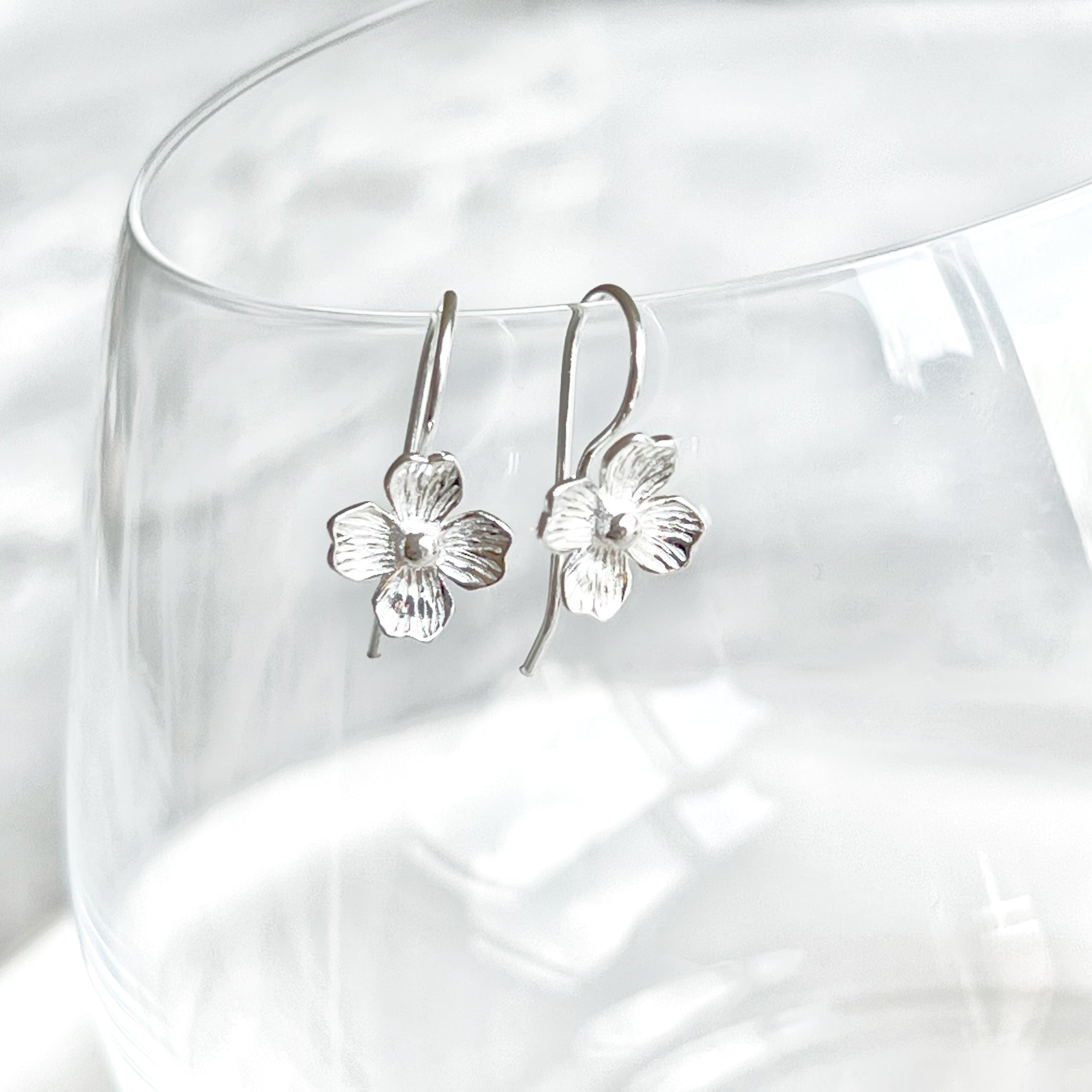 A pair of elegant silver hydrangea flower ear wire earrings, showcasing intricate floral design and sterling silver craftsmanship.