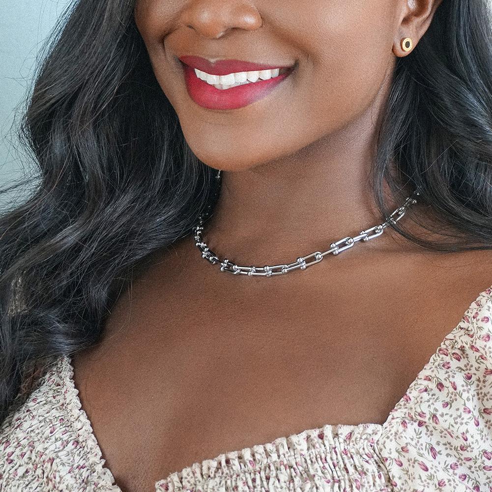 Silver Le Cheval jewelry set featuring a necklace, bracelet, and ring with horse shoe links, elegantly displayed in a gift box.