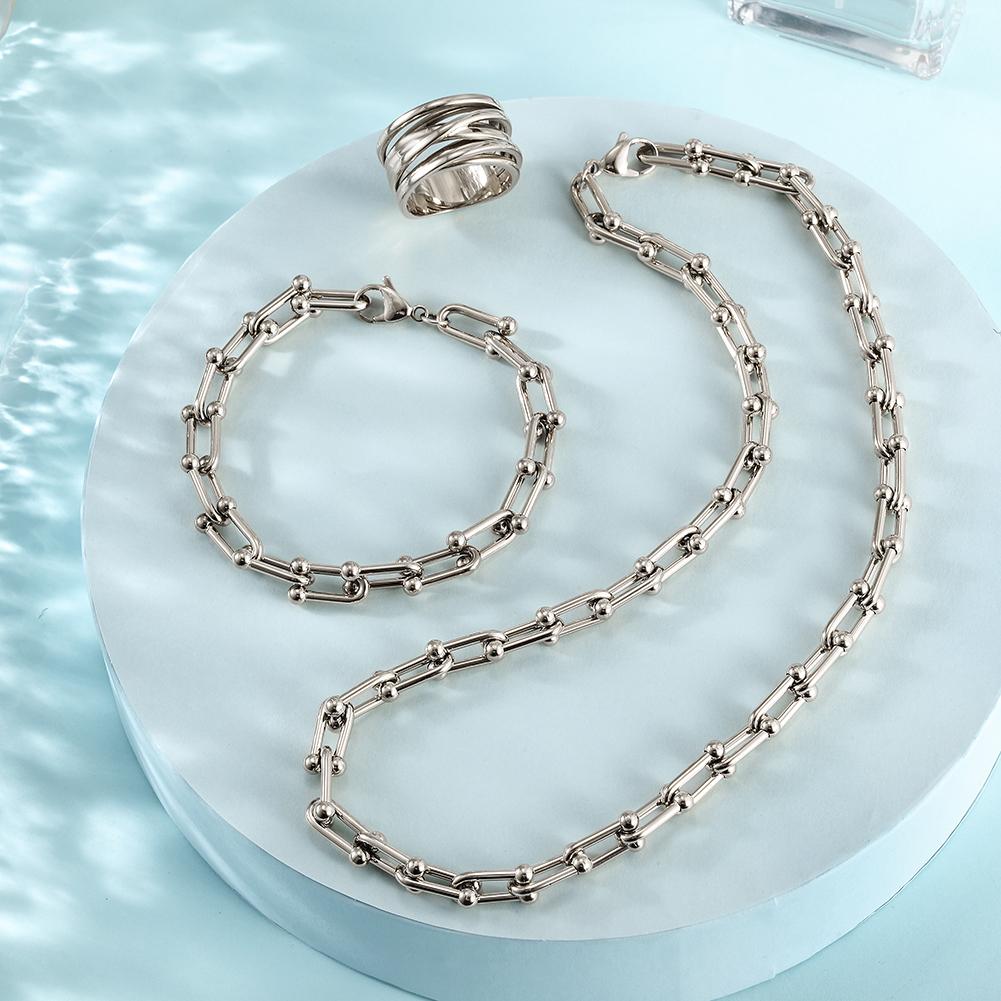 Silver Le Cheval jewelry set featuring a necklace, bracelet, and ring with horse shoe links, elegantly displayed in a gift box.