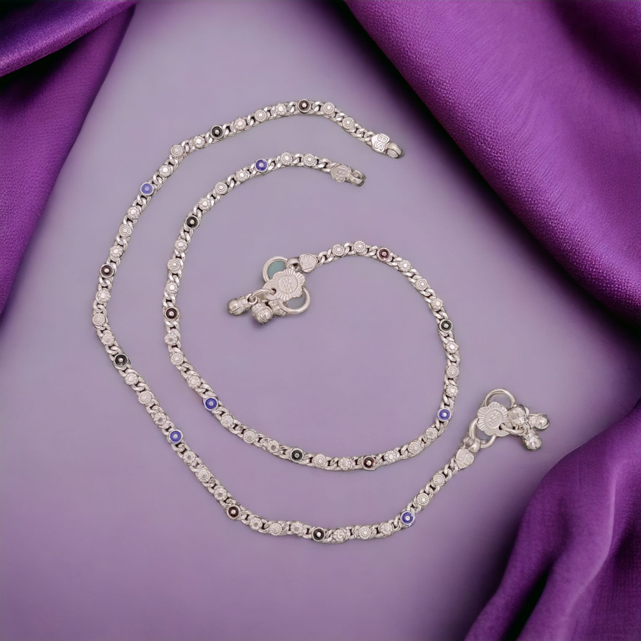 Silver plated anklet featuring a link chain design with blue evil eye beads, showcasing a minimalistic and elegant style.