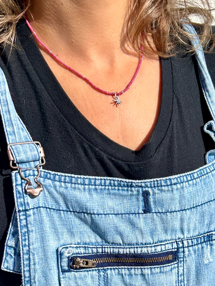 Silver Starburst Bling Magenta Stretchy Seed Bead Necklace featuring magenta Czech glass beads and a metallic silver starburst charm.