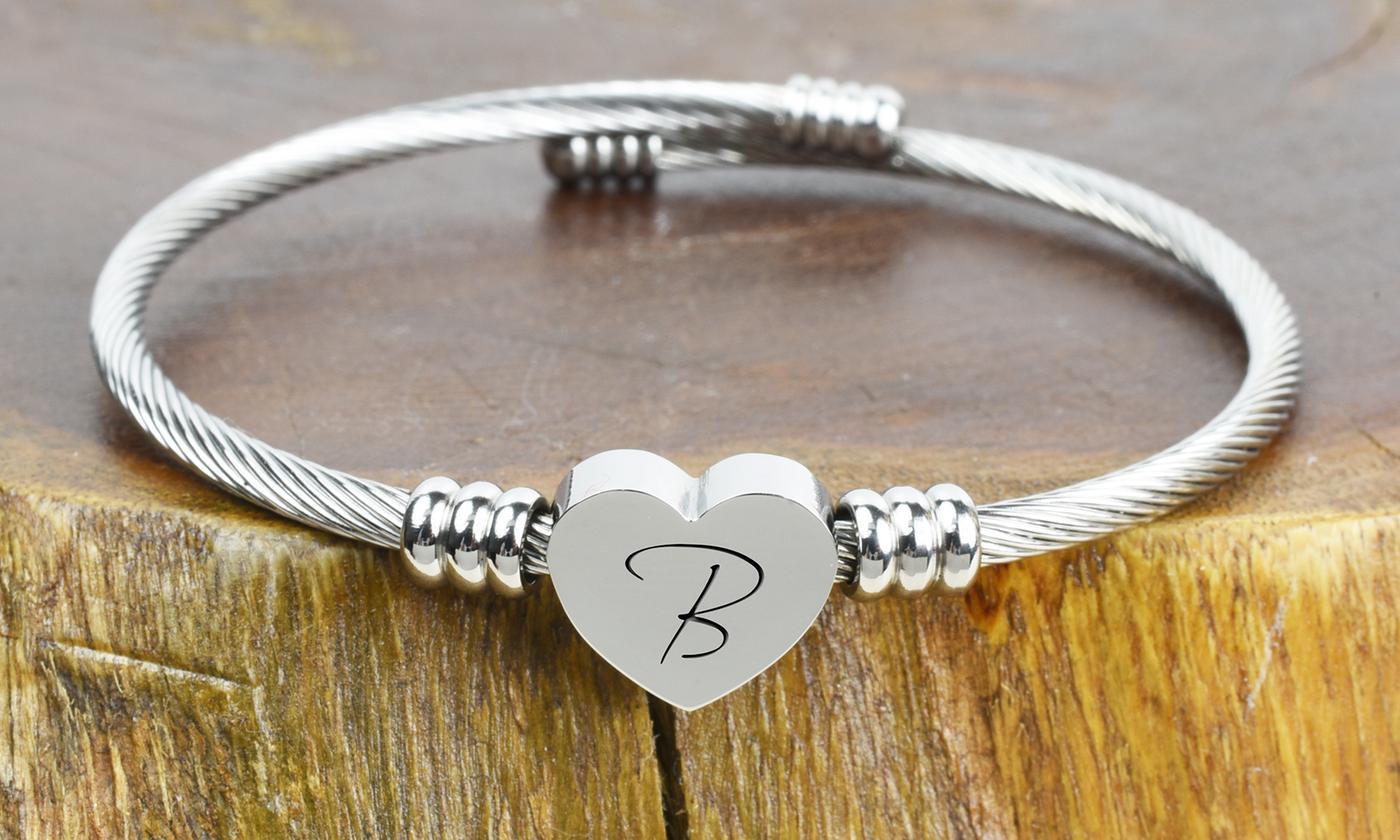 Solid stainless steel heart initial cable bangle featuring a polished finish and customizable letter charm.