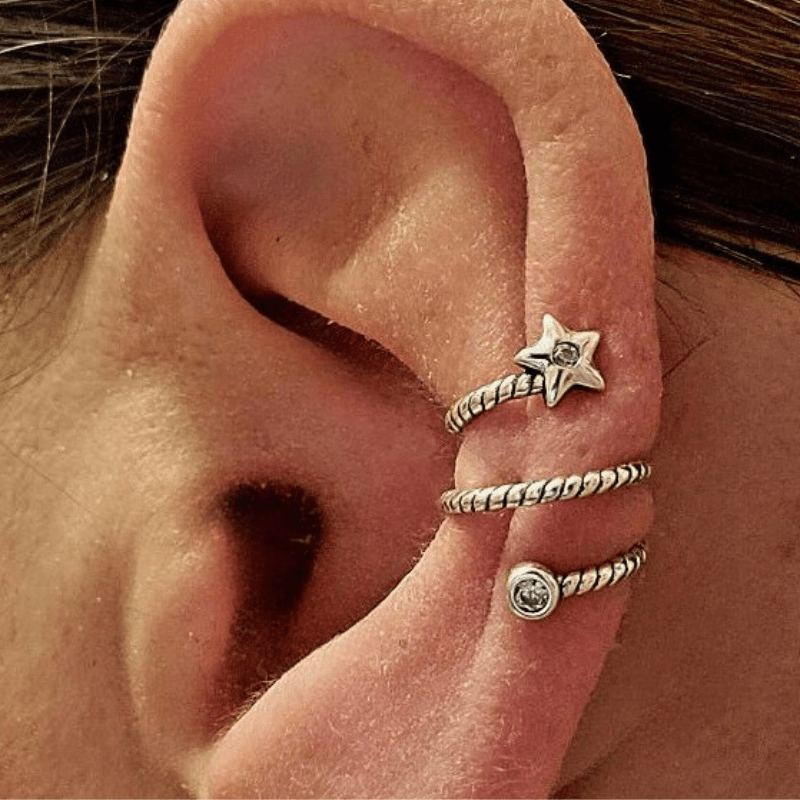 A stylish Star Twist Ear Cuff made from .925 Sterling silver with sparkling CZ studs, featuring a unique twist design and star motif.