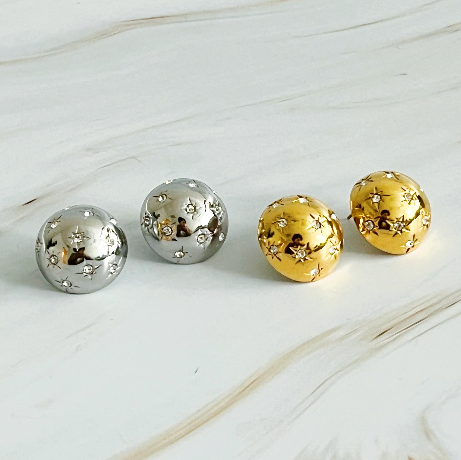 Elegant Starlight Sphere Stud Earrings in gold and silver finishes, showcasing a unique design with a sparkling shine.