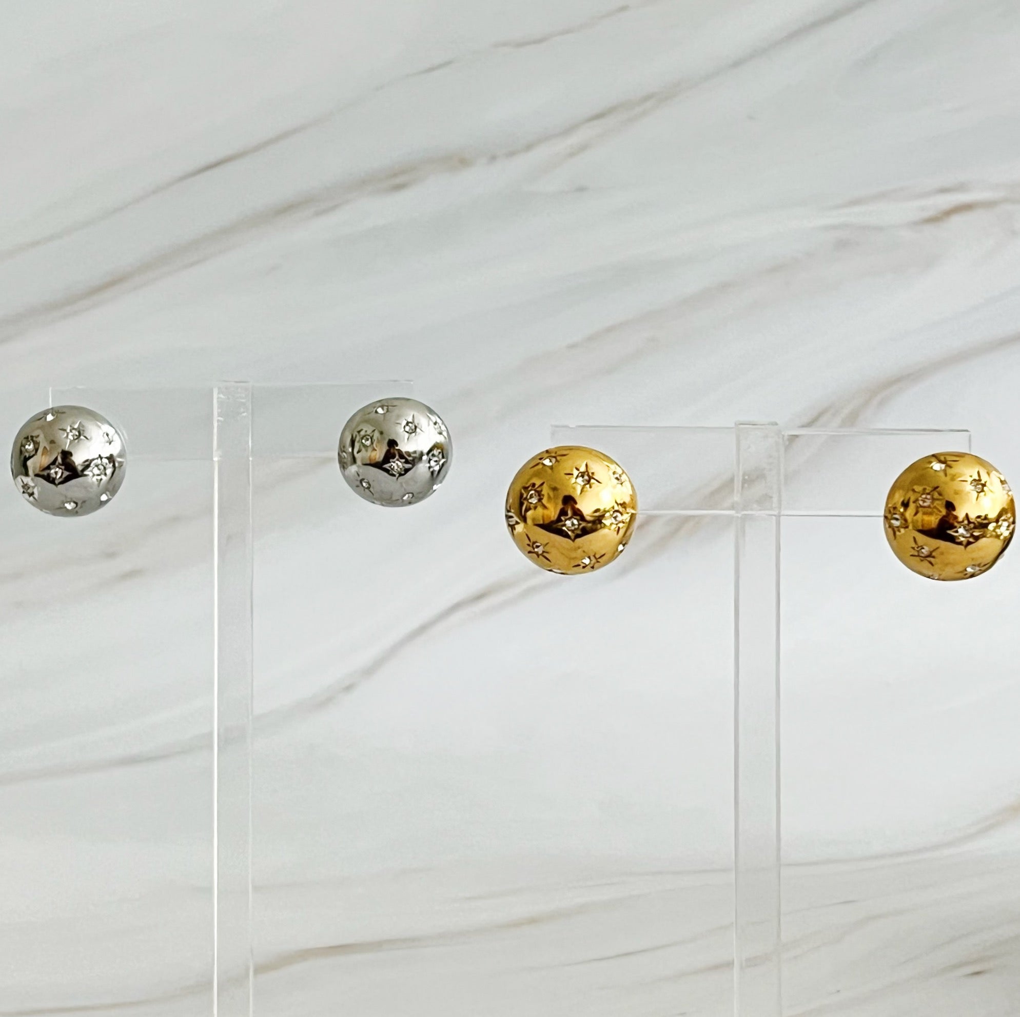 Elegant Starlight Sphere Stud Earrings in gold and silver finishes, showcasing a unique design with a sparkling shine.