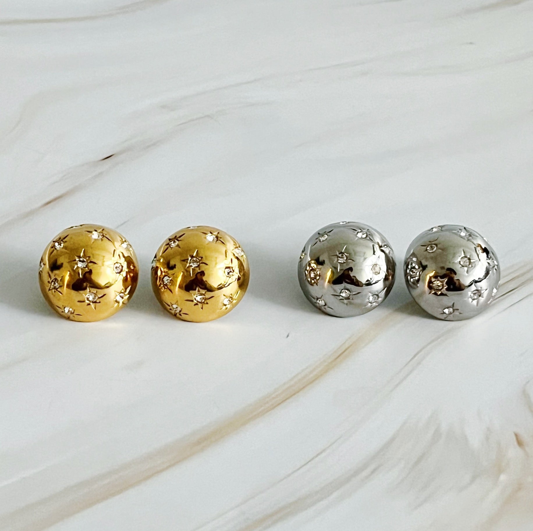 Elegant Starlight Sphere Stud Earrings in gold and silver finishes, showcasing a unique design with a sparkling shine.