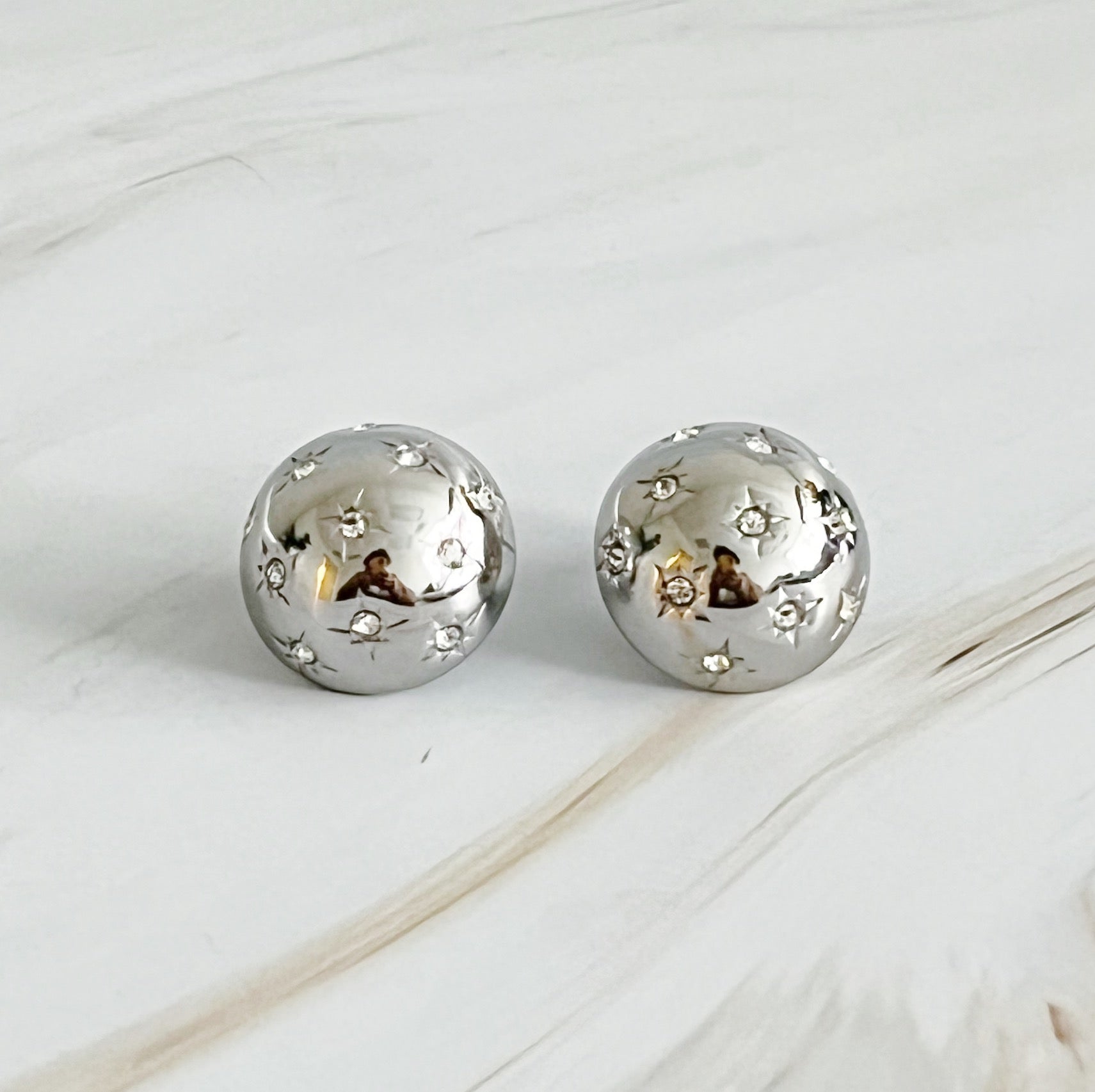 Elegant Starlight Sphere Stud Earrings in gold and silver finishes, showcasing a unique design with a sparkling shine.