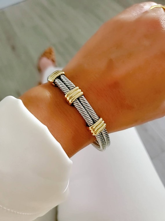 A stylish Statement Double Bangle Bracelet featuring gold accents and a silver cable design, perfect for elegant occasions.