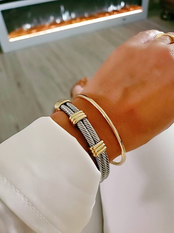 A stylish Statement Double Bangle Bracelet featuring gold accents and a silver cable design, perfect for elegant occasions.