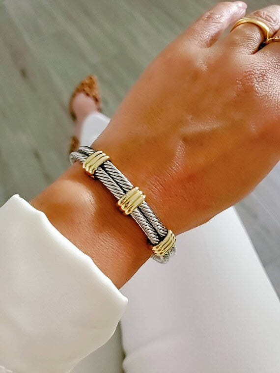 A stylish Statement Double Bangle Bracelet featuring gold accents and a silver cable design, perfect for elegant occasions.