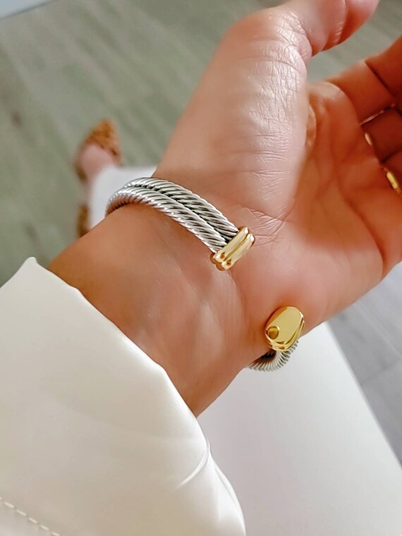 A stylish Statement Double Bangle Bracelet featuring gold accents and a silver cable design, perfect for elegant occasions.