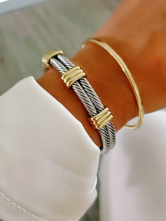 A stylish Statement Double Bangle Bracelet featuring gold accents and a silver cable design, perfect for elegant occasions.