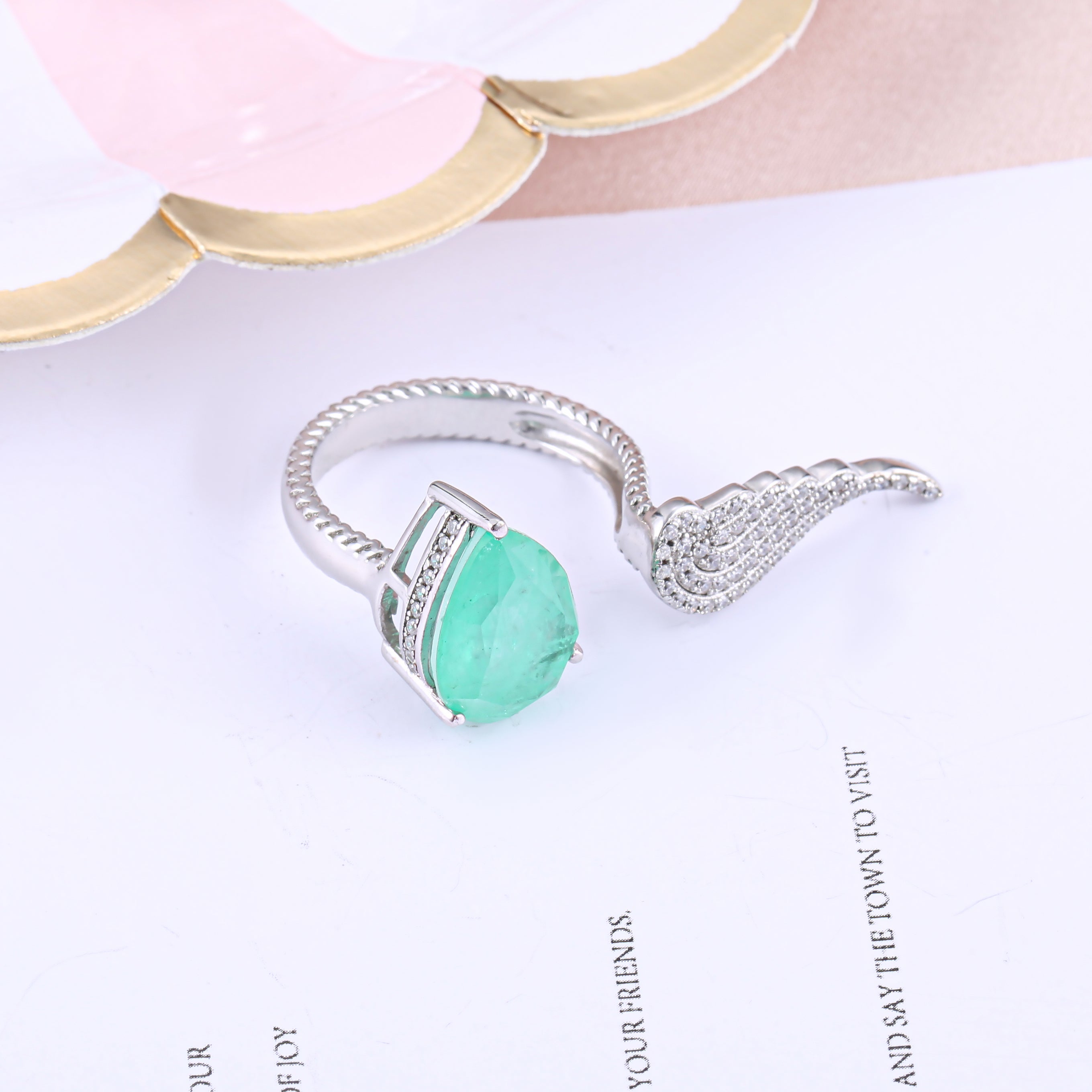 Sterling silver feather open ring with white sapphire, showcasing intricate design and real white gold finish.